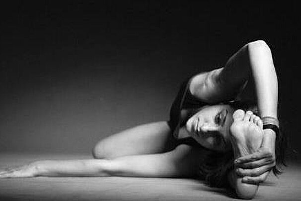 A black and white photo of a woman doing a yoga pose