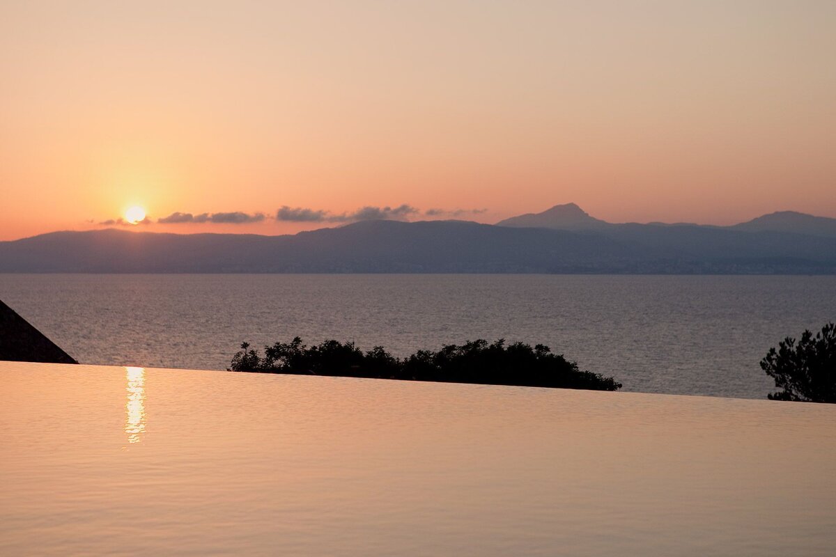 A sunset over a body of water with mountains in the background