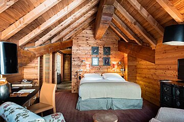 A bedroom in a wooden cabin with a large bed
