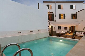 A white building with a swimming pool in front of it