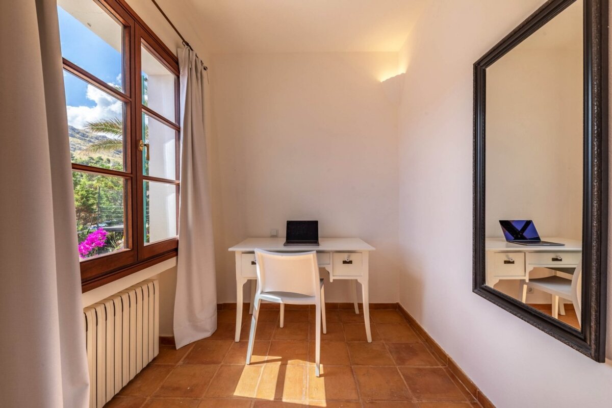 A small room with a desk and chair and a large mirror