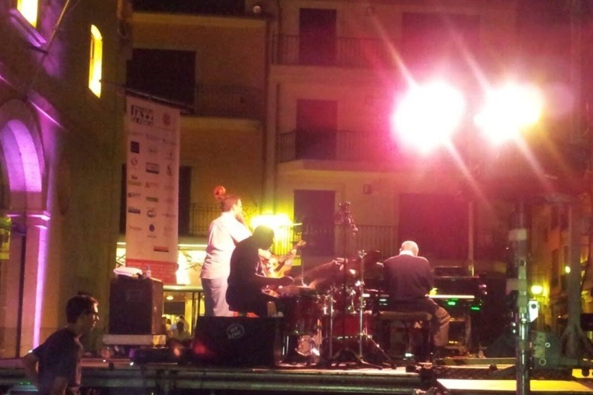 A man playing a piano in front of a sign that says fitz