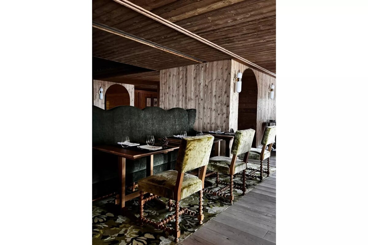 A dining room with tables and chairs and a wooden ceiling