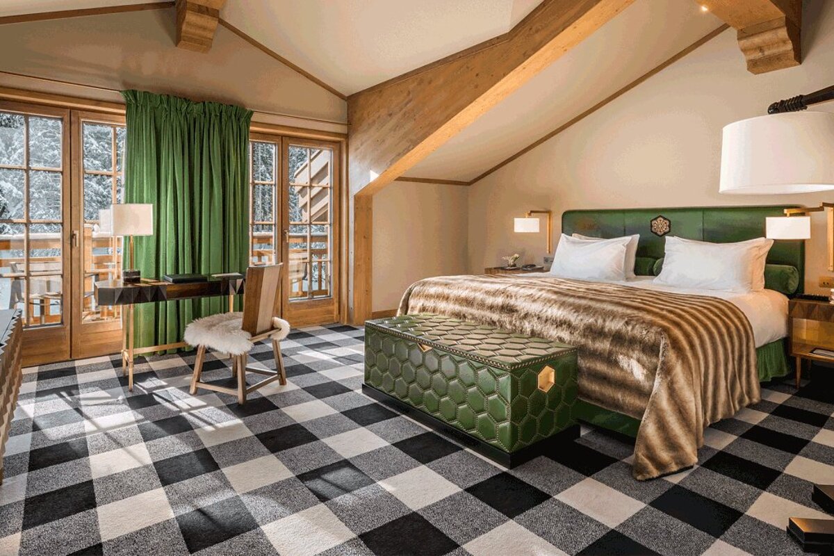 A bedroom with a large bed and a desk
