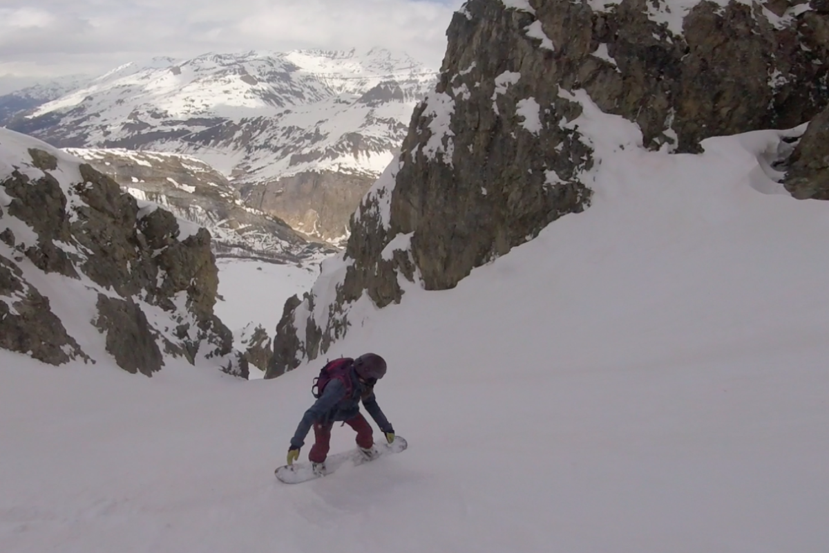 a snowboarder about to drop into a gully