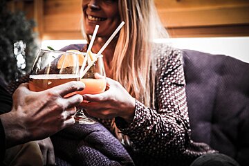 A man and a woman are toasting with drinks