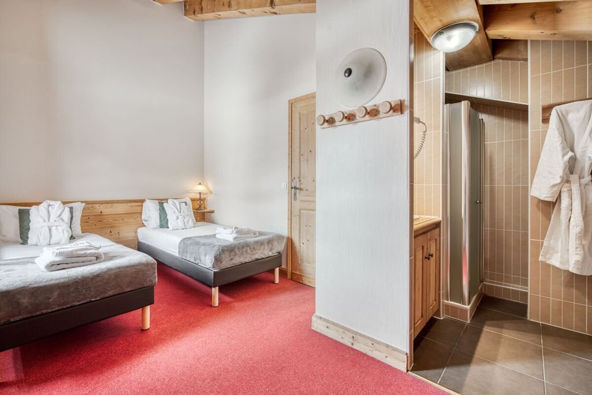 A hotel room with two beds and a shower