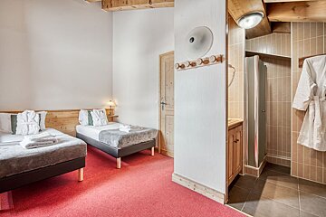 A hotel room with two beds and a shower