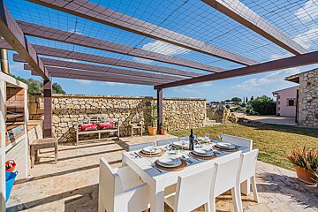A patio with a table and chairs under a pergola