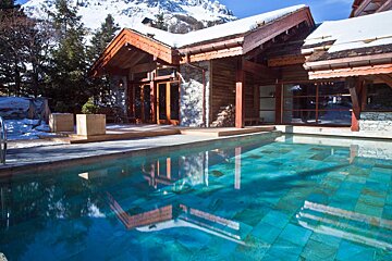 A house with a swimming pool in front of it