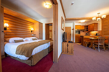 A hotel room with two beds and a flat screen tv