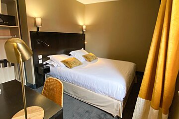 A hotel room with a bed and a desk