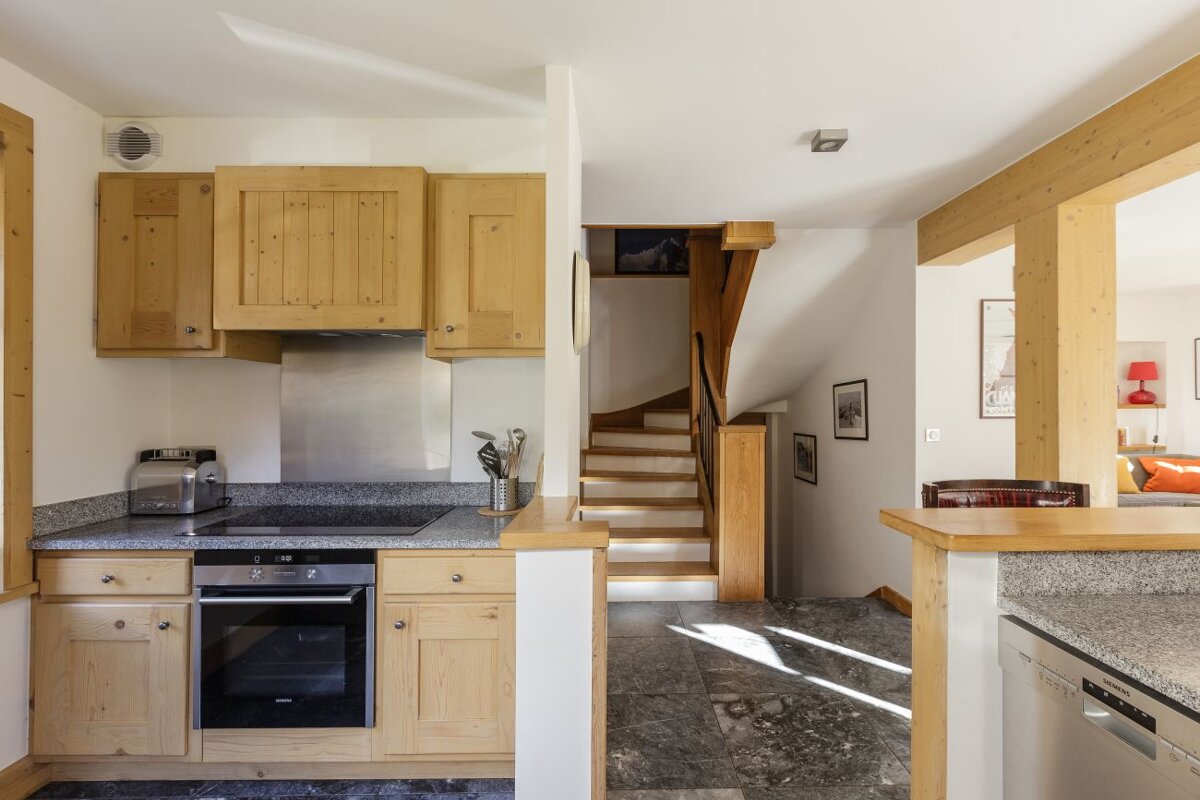 A kitchen with wooden cabinets and a stainless steel stove top oven