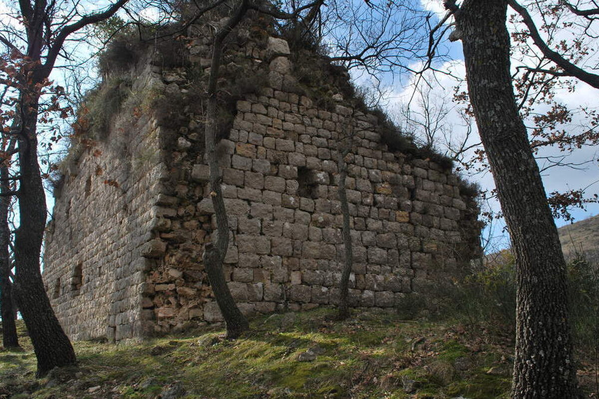 A brick building surrounded by trees with a blue sky in the background