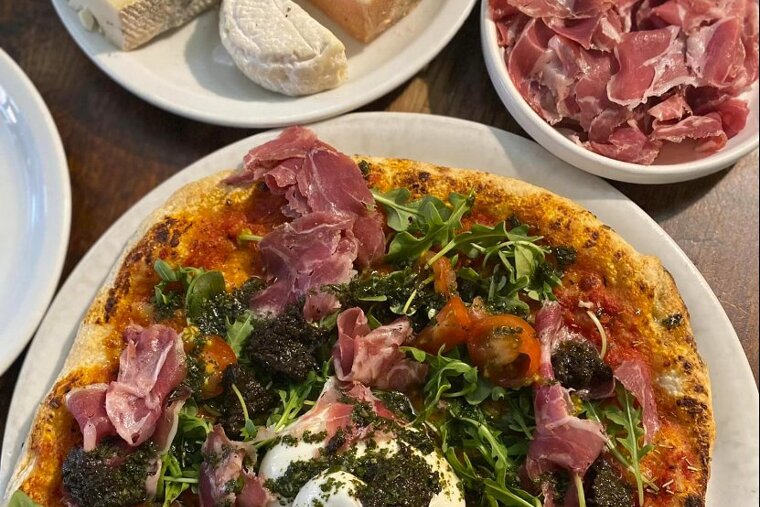 A pizza with a lot of meat and vegetables on it