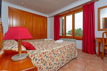 A bedroom with a large bed and red curtains