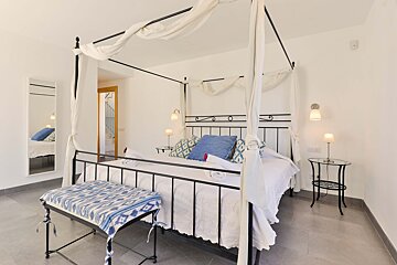 A bedroom with a canopy bed and a mirror