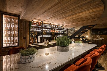 A bar with a lot of wine glasses on the shelves