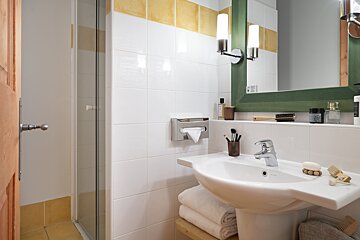 A bathroom with a sink and a green mirror