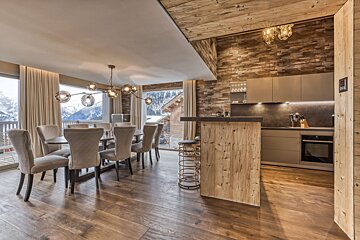A kitchen and dining area with a wooden table and chairs