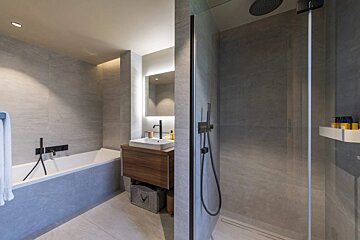 A bathroom with a sink and a walk in shower