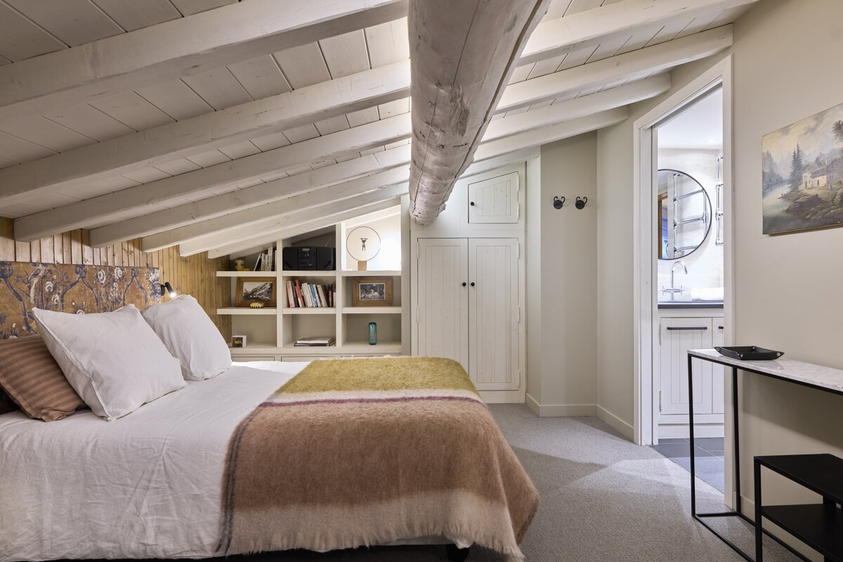 A bedroom with a bed and a painting on the wall