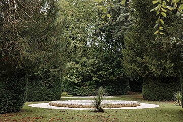A fountain in the middle of a lush green forest