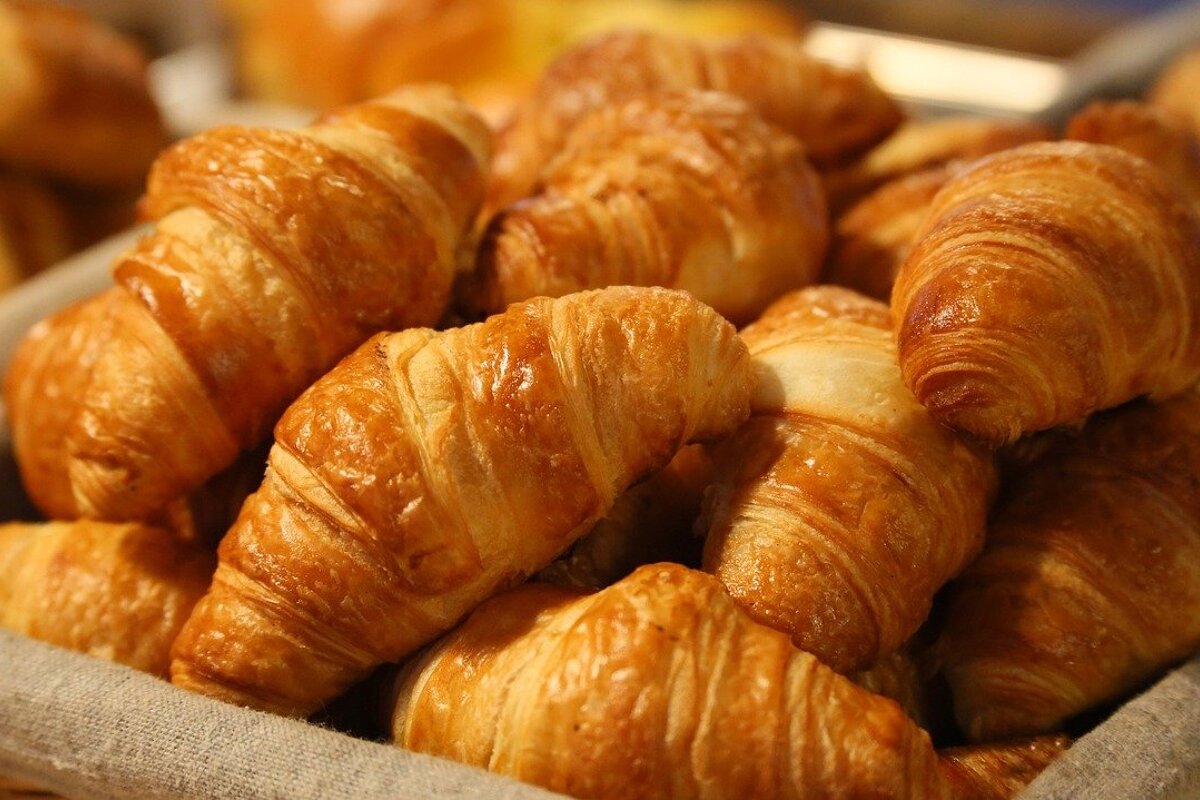 A bunch of croissants are sitting in a basket