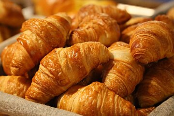 A bunch of croissants are sitting in a basket