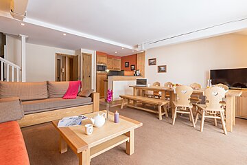 A living room with a couch and a table and chairs
