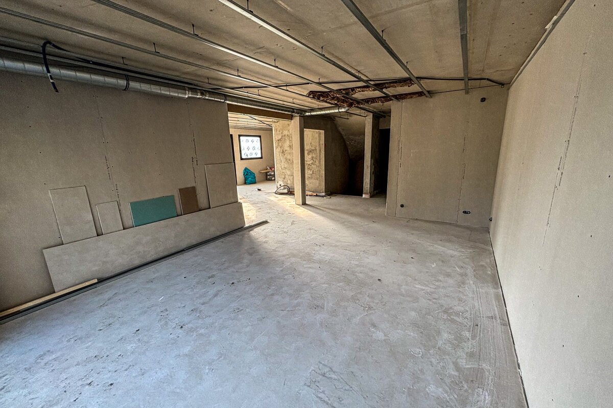 An empty room with a ceiling that has a few wires hanging from it