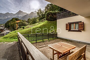 A balcony with a wooden table and bench with the word ten80 on the bottom