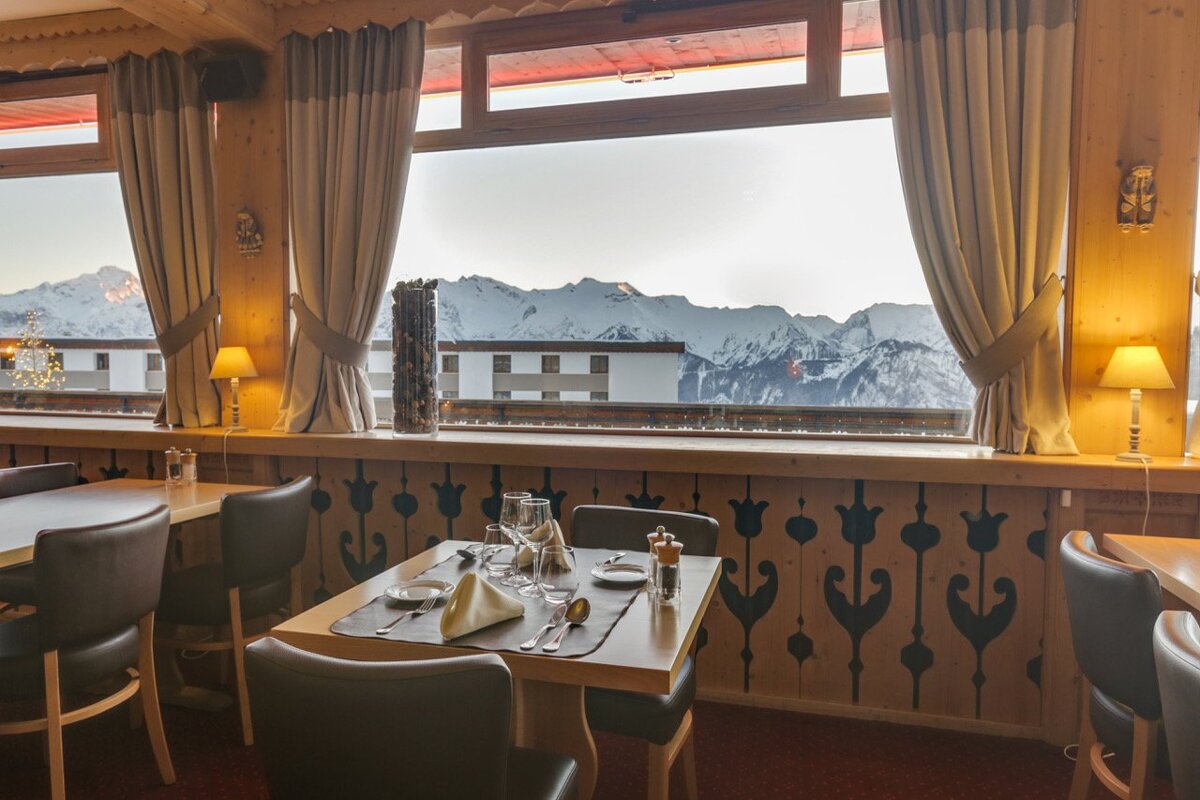 A dining room with a view of snowy mountains