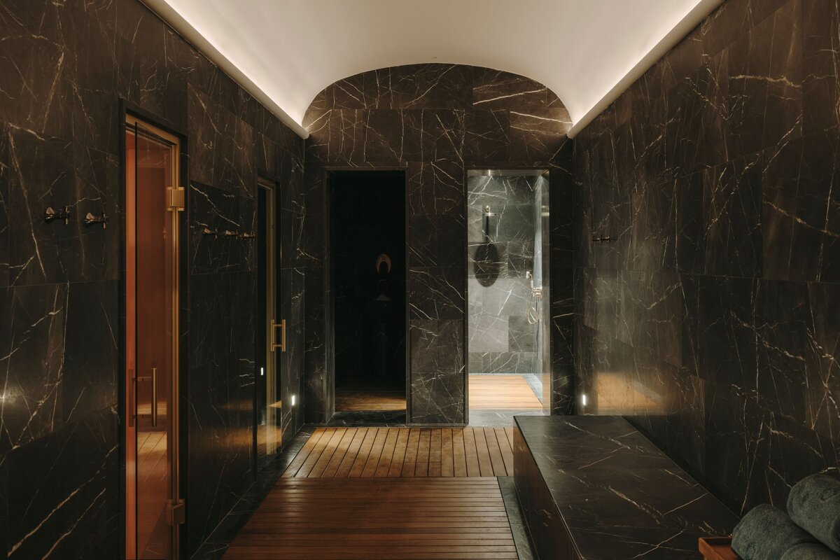A dark hallway with marble walls and wooden floors