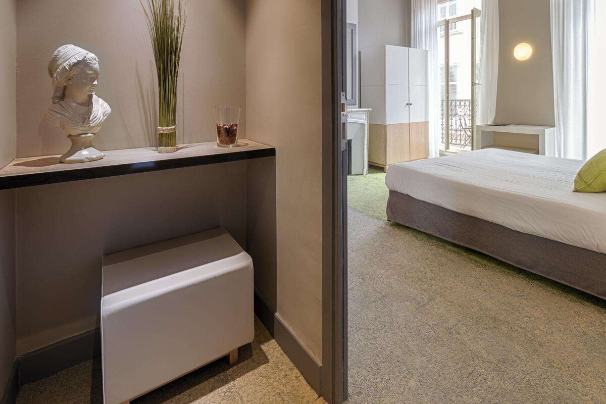 A hotel room with a statue of a woman on a shelf