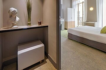 A hotel room with a statue of a woman on a shelf