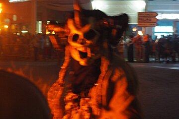 a devil walking the streets with a skull mask