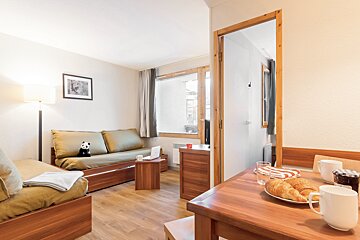 A living room with a couch and a table with croissants on it