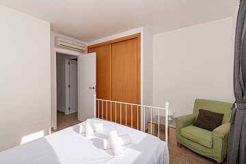 A bedroom with a bed and a green chair