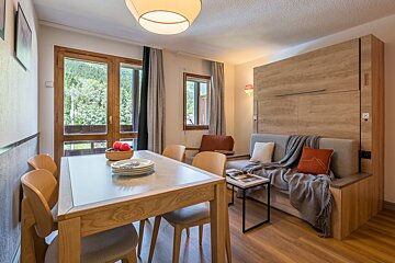 A living room with a table and chairs and a couch