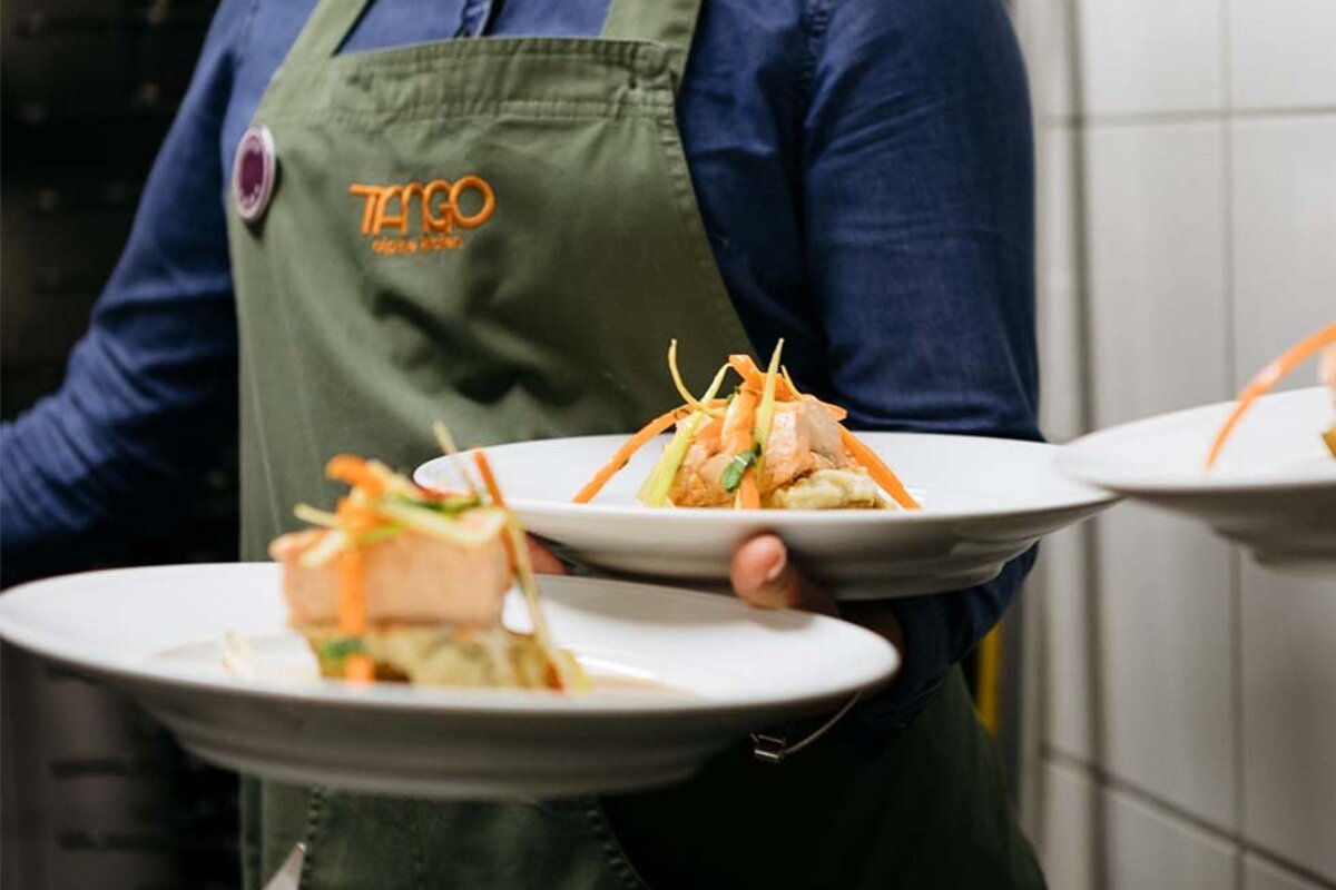 A person wearing an apron that says tango on it