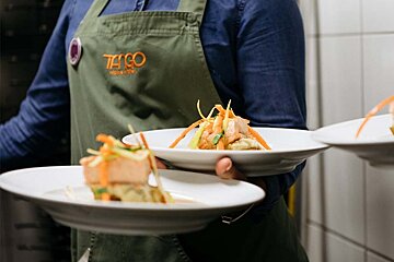 A person wearing an apron that says tango on it