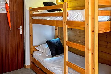 A bunk bed in a room with an orange umbrella
