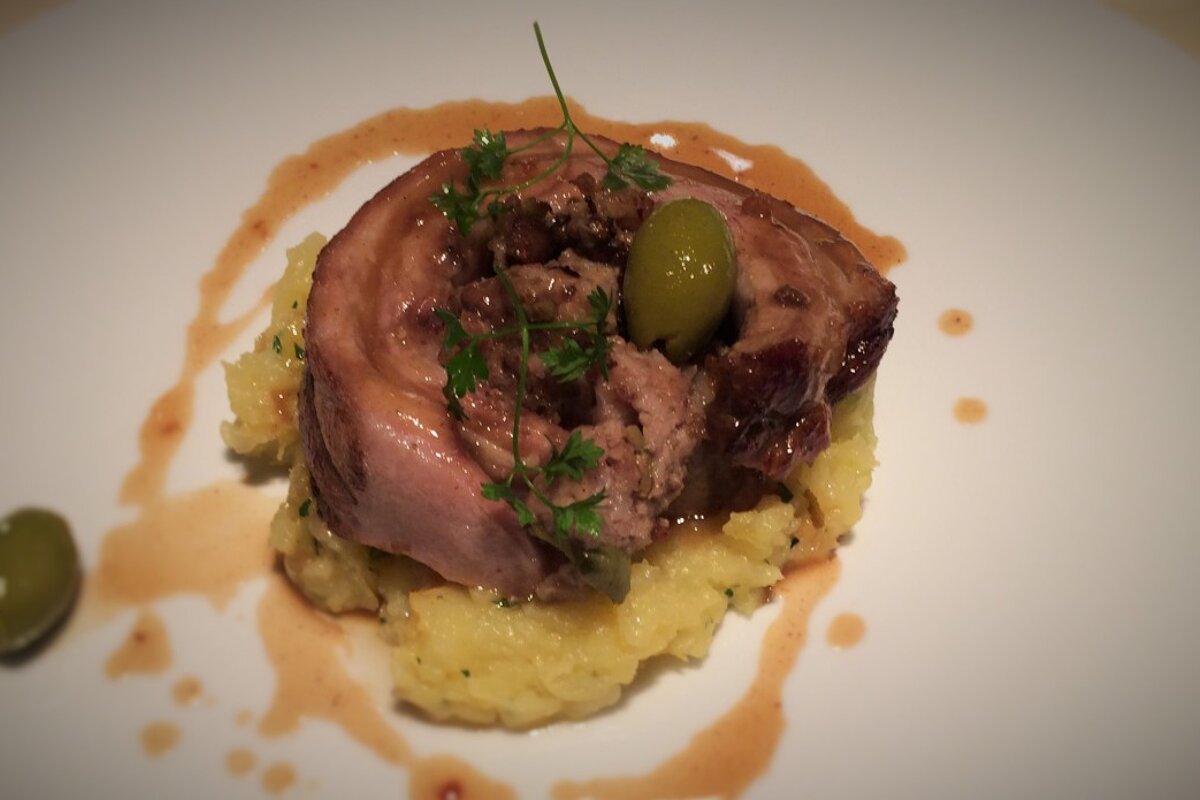 A plate of food with a green olive on top