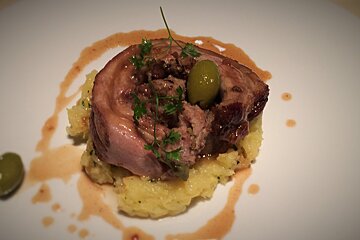 A plate of food with a green olive on top