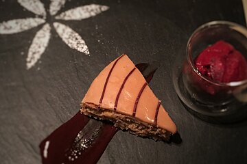 A slice of cake next to a glass of ice cream