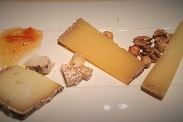 A white plate topped with different types of cheese and nuts