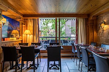 A dining room with tables and chairs and a large window