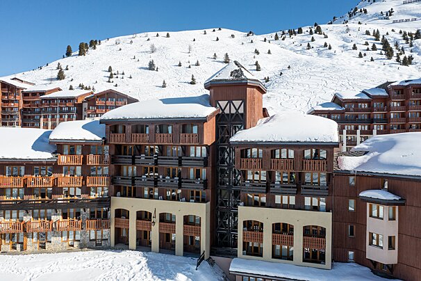 A snow covered building with the letter x on the top