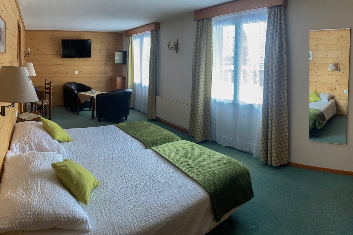 A hotel room with two beds and a television